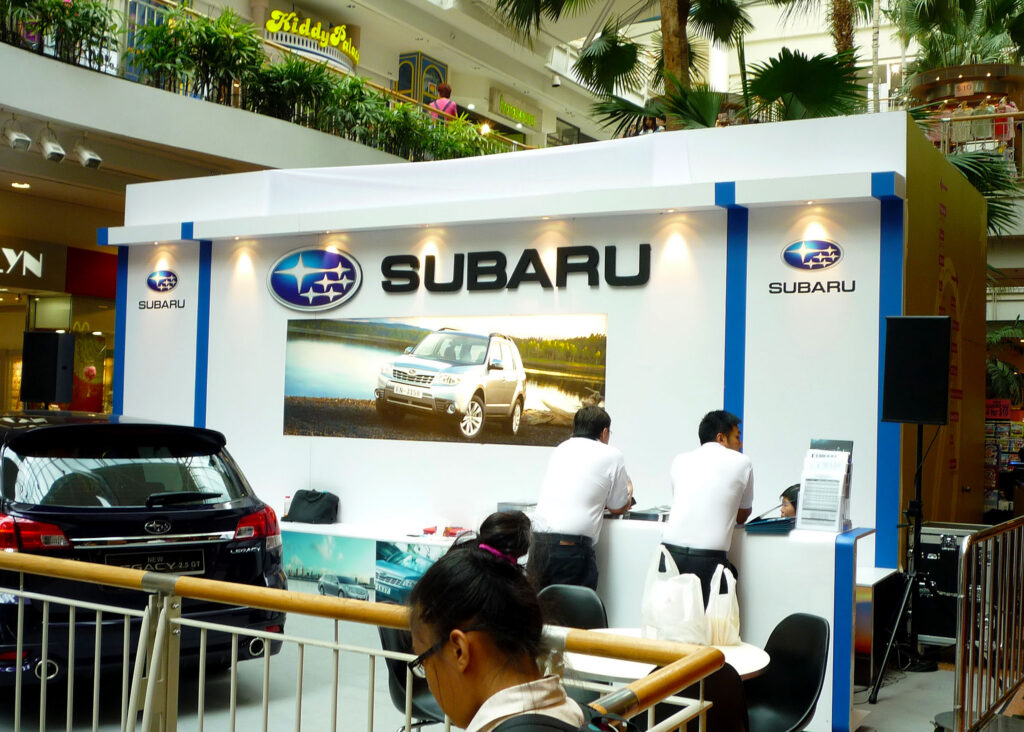 Subaru exhibition display with overhead branding, display panels and visitors