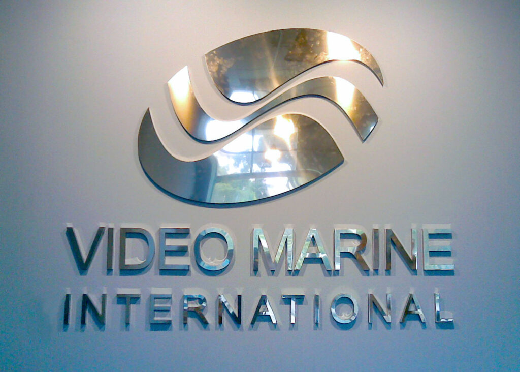 Brushed metal symbol and Video Marine International lettering mounted on a wall